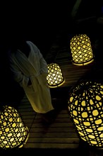 Woman with Bathrobe Standing Cloe to Illuminated Lamps at Night