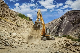 Excavator doing road construction repair in Himalayas. Ladakh, Jammu and Kashmir, India, Asia