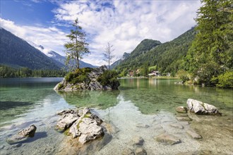 Hintersee near Ramsau with clear green water, surrounded by forests and mountains under a cloudy