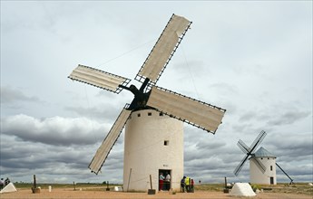 Large white windmills in an open landscape with dramatic skies and cloud formations, Campo de