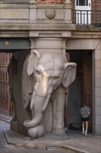 Pedestrian walking past monumental stone elephant, Elephant Gate or Elephant Portal or