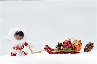 Christmas decoration, Inuit pulling sleigh with Christmas presents through the snow