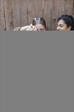 Young woman giving a lamb a bottle of milk in her arms, North Sea island of Borkum, 18.05.2024.