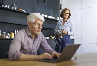 Symbolic photo on the subject of division of labour for couples in the household. A man sits in a