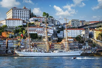 View of Porto city and Douro river with sailing ship from famous tourist viewpoint Marginal de Gaia