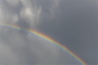 Rainbow appears in rain clouds in spring. Bas Rhin, Alsace, France, Europe