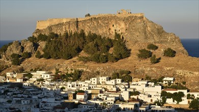 Village and old castle in the golden light of the setting sun, shadows on the houses, Acropolis of