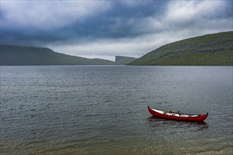 Little red boat in a lake in Vagar, Faroe islands, Denmark, Europe