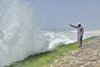 Local man watching the surf at the corniche of Salalah during the monsoon season, or Khareef