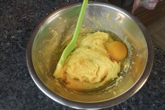 Swabian cuisine, preparing choux pastry for mini cream puffs, adding egg to raw choux pastry,