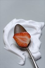 Strawberry with cream on a spoon