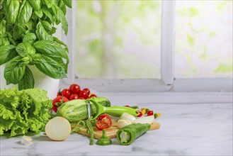 Fresh vegetables on a board, salad ingredients, cucumber, tomatoes, lettuce, basil, pepperoni,