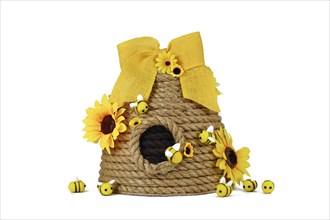 DIY rope beehive decoration with fake flowers, jute rope and cute felt bees on white background