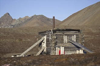 Wooden hunting log cabin tightly shut with logs against raiding polar bears on Svalbard,