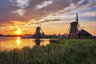 Netherlands rural scene, - windmills at famous tourist site Zaanse Schans in Holland on sunset with