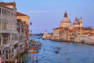 Panorama of Venice Grand Canal with boats and Santa Maria della Salute church on sunset from Ponte