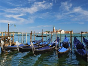 Gondolas and gondolier in lagoon of Venice by Saint Mark (San Marco) square with San Giorgio di