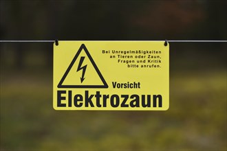 Leimen, Germany, April 2020: Yellow electric fence warning sign with German text saying 'Attention,