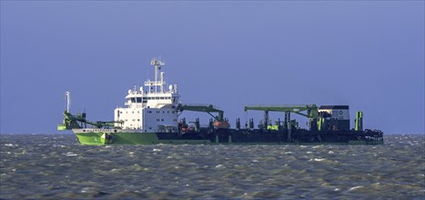 DEME trailing suction hopper dredger Uilenspiegel at sea, used for sand replenishment, beach