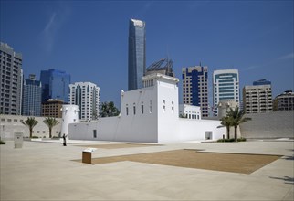 Old fort and museum Qasr al Hosn in front of skyscrapers, oldest building in Abu Dhabi City,