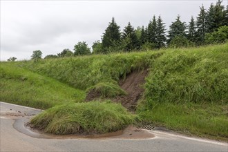 Symbolic image of climate change, slippery slope on a country road after heavy rainfall, near