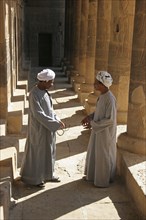 Two Egyptian men carrying jalabiyas at the Philae Temple of Isis on Agilkia Island in Lake Nasser,