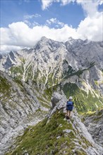 Mountaineer climbing Waxenstein, Alpspitze Wetterstein range in the background,