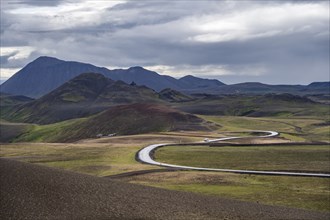 Road through volcanic landscape with colourful hills, Krafla geothermal area, Northern Iceland,