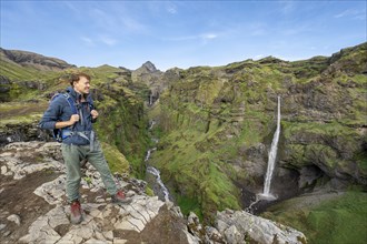 Hikers at the canyon, mountain landscape with canyon, Hangandifoss waterfall in Múlagljúfur Canyon,