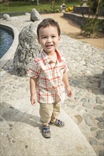 Young chinese and caucasian boy having fun at the park and duck pond