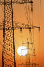 Overhead power lines, high-voltage pylons, power lines, setting sun, sunset, Baden-Württemberg