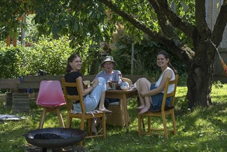 Three woman drinking coffee in the garden, Mecklenburg-Vorpommern, Germany, Europe