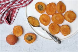 Apricot, apricot halves on plate with spoon