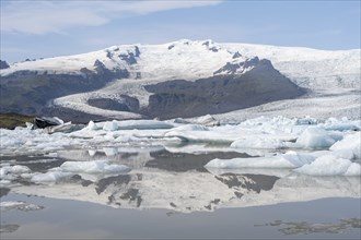 Sveinstindur peak reflected in glacier lagoon, Fjallsárlón ice lagoon, ice floes in front of