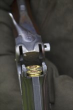 Hunter's open double-barreled break-action shotgun with two small-shot cartridges, shotgun shells