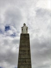 Statue of Mary on high pedestal, Cloudy Sky, Arromanches-les-Bains, Gold Beach, Normandy, France,