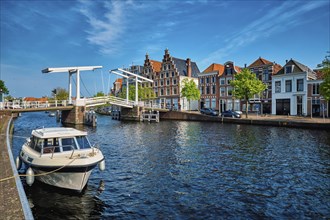 Spaarne river with boat and Gravestenenbrug bridge famous tourist landmark in Haarlem, Netherlands