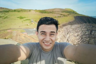 Adventurous man taking a selfie at a viewpoint. Close up of person taking an adventure selfie,