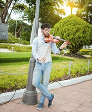 Portrait of man playing violin in the street. Jacket artist playing violin outdoors, Image of a