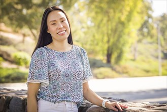 Outdoor portrait of a happy chinese young adult woman