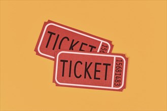 Two old fashioned red tickets on yellow background