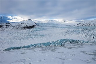 Snow-covered icebergs in the Fjallsarlon glacier lagoon, with the Öraefajökull glacier behind,