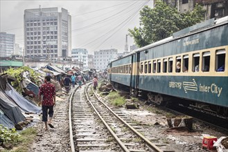 Passenger train travelling through a slum settlement, Tejgaon Slum Area, Dhaka, Bangladesh, Asia