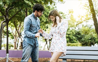 Young couple arguing misunderstanding in a park, Unhappy couple standing arguing in a park.