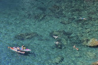 Bathers in the rocky bay of Corniglia, Cinque Terre, province of La Spezia, Liguria, Italy, Europe