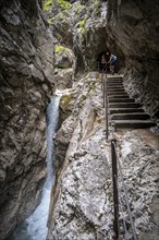 Hiker in a gorge, Hammersbach flows through Höllentalklamm, near Garmisch-Partenkirchen,