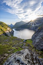 Mountain landscape with lake Tennesvatnet, at sunrise with sun star, Moskenesøya, Lofoten,