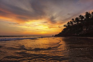 Sunset on Varkala beach popular tourist destination in Kerala state, South India