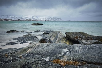 Waves of Norwegian sea on rocky beach of fjord. Ramberg beach, Lofoten islands, Norway, Europe