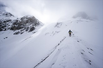 Ski tourers in a snowy mountain landscape, ascent to the Wildhorn, cloudy mood, high tour, Bernese